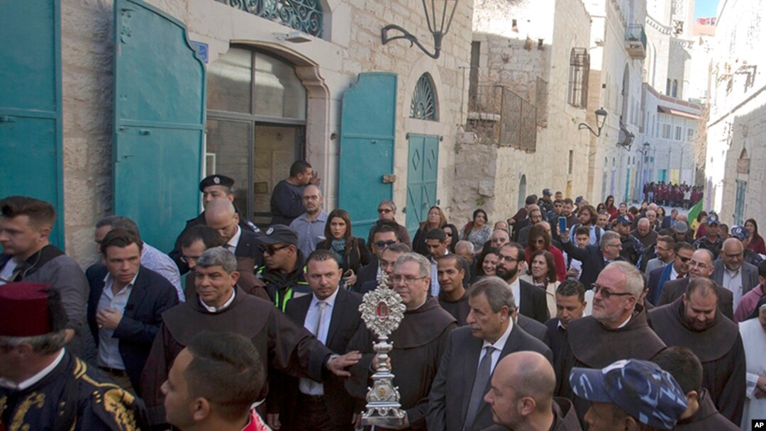 Christian clergymen carry a wooden relic believed to be from Jesus' manger outside the Church of the Nativity, traditionally believed by Christians to be the birthplace of Jesus Christ, in the West Bank city of Bethlehem, Nov. 30, 2019.