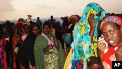 FILE - Women and children holding their pink tickets queue for the evening meal at the Dollo Ado transit center in Ethiopia, October 26, 2011. (VOA P. Heinlein)