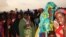 FILE - Women and children holding their pink tickets queue for the evening meal at the Dollo Ado transit center in Ethiopia, October 26, 2011. (VOA P. Heinlein)