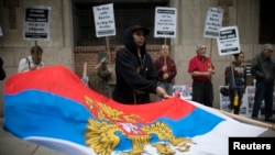 FILE - A protester waves Russia's presidential flag during a demonstration outside Ukraine's consulate in New York May 8, 2014.