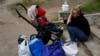 為逃離俄軍的轟炸，一名哭泣的烏克蘭媽媽和她的一歲的兒子正在等候巴士疏散到哈爾科夫。（2024年5月14日）