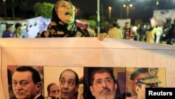 A protester opposed tot the Egyptian army and government shouts slogans, holds a banner during a demonstration against the army and government at Abdeen square in downtown Cairo, Nov. 18, 2013.