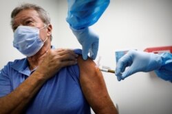 FILE - A volunteer is injected with a vaccine as he participates in a coronavirus disease (COVID-19) vaccination study at the Research Centers of America, in Hollywood, Florida, Sept. 24, 2020.