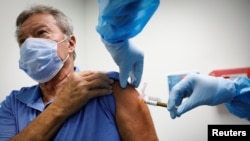 FILE - A volunteer is injected with a vaccine as he participates in a coronavirus disease (COVID-19) vaccination study at the Research Centers of America, in Hollywood, Florida, Sept. 24, 2020.