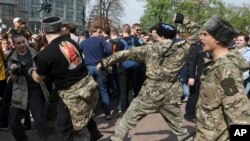 Fighters of National Liberation movement clash with protesters during clashes at a demonstration against President Vladimir Putin in Pushkin Square in Moscow, Russia, Saturday, May 5, 2018. 