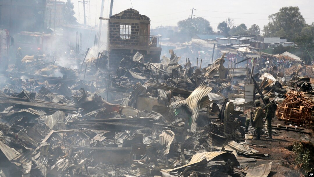 Sisa-sisa kios pedagang masih mengepulkan asap setelah api membakar sebuah pasar di Nairobi, Kenya. 28 Juni 2018 (foto: AP Photo/Khalil Senosi).