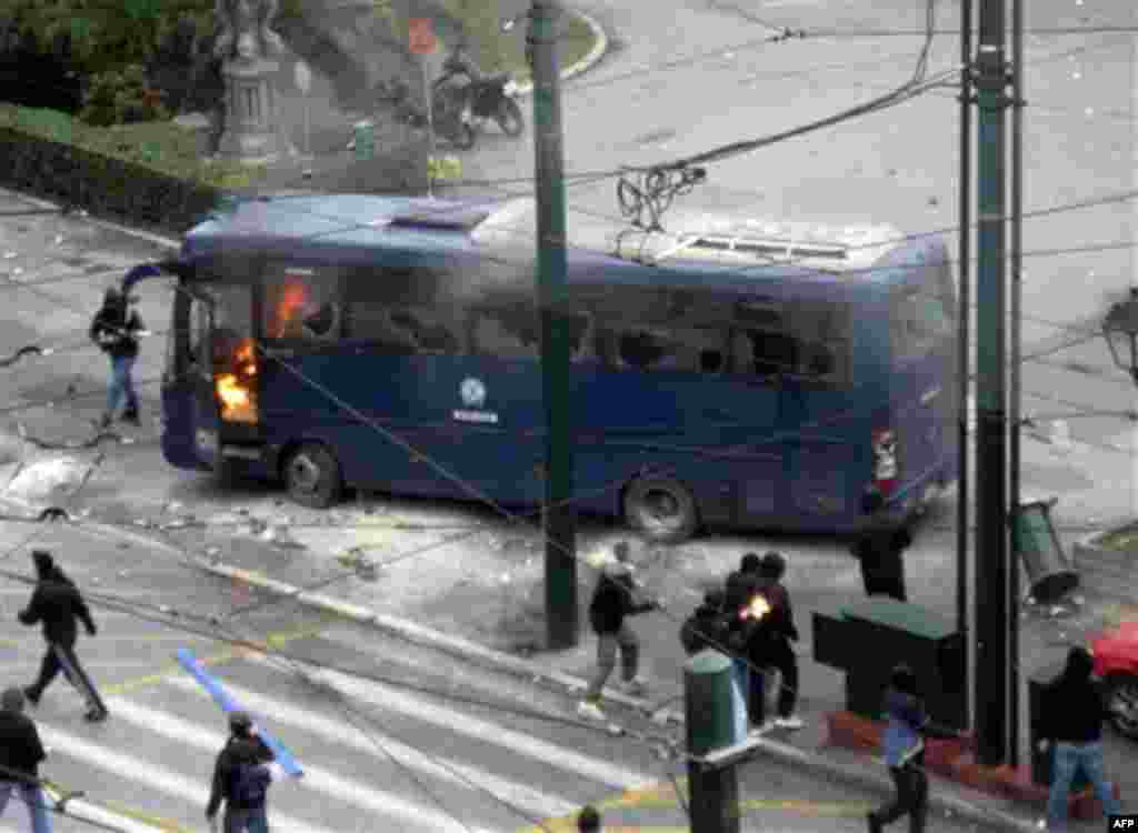 Protesters set fire to a police bus during clashes in Athens, Wednesday, Dec. 15, 2010. Hundreds of protesters clashed with riot police across central Athens Wednesday, smashing cars and hurling gasoline bombs during a massive labor protest against the go