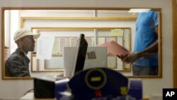 FILE - A patient, right, is attended to at an AIDS clinic at the Helen Joseph Hospital in Johannesburg.