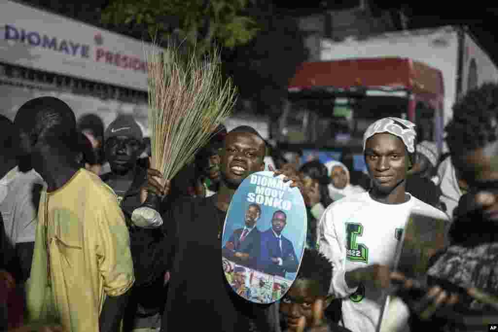 Apoiantes do candidato presidencial Bassirou Diomaye Faye e do principal líder da oposição senegalesa, Ousmane Sonko, reúnem-se à porta das suas sedes de campanha enquanto aguardam os resultados das eleições presidenciais, em Dakar, Senegal, domingo, 24 de março de 2024.&nbsp;