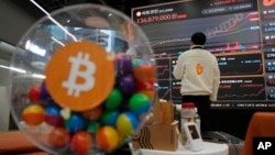 Un empleado observa un cartel electrónico con los precios del bitcoin y otras criptomonedas en la sala de descanso del mercado de criptomonedas de Bithumb en Seúl, Corea del Sur, el 21 de noviembre de 2024. (AP/Ahn Young-joon)