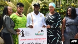 Le tourisme, une activité génératrice de revenus pour l’Ouganda.
Le ministre ougandais du Tourisme, Godfrey Kiwanda (C), pose aux côtés des participants lors du lancement du concours de beauté Miss Curvy dans la capitale Kampala, le 5 février 2019.
