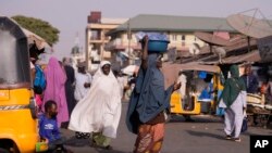 FILE - A woman sells sachets water on the street in Kaduna, Nigeria, Friday , March. 8, 2024.