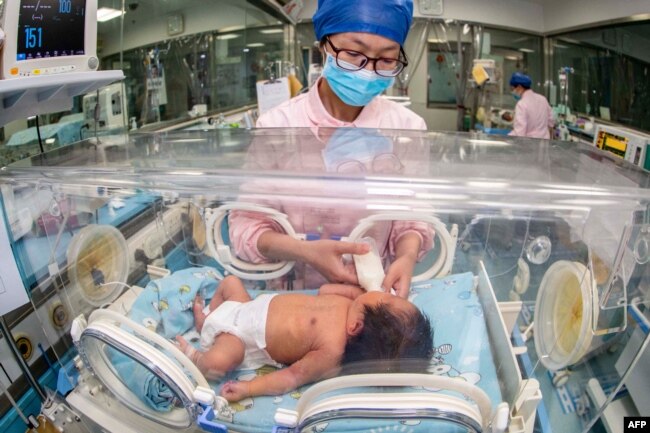 FILE - This file photo taken on May 12, 2023 shows a nurse taking care of a newborn baby at a hospital in Taizhou. China's population shrank in 2023 as the country's birth rate slows in the face of mounting financial pressures and shifting social attitudes. (Photo by AFP)