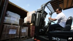 A lift truck driver offloads aid materials for Syria at the UNHCR warehouses in Dubai, part of the International Humanitarian City (IHC), the largest global stockpile for the UNHCR in Dubai, United Arab Emirates, Feb. 20, 2014.