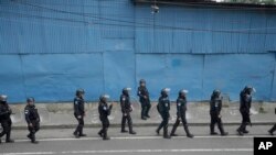 Policías antimotines marchan por una carretera bloqueada por manifestantes en Ciudad de Guatemala el martes 10 de octubre de 2023. 