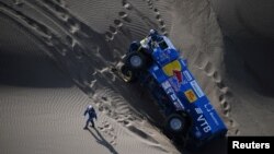 Eduard Nikolaev dan navigator Evgeny Yakovlev dari Rusia dekat truk Kamaz yang mereka kendarai dalam Reli Dakar 2018 dari Peru-Bolivia dan Argentina, 10 Januari 2018.