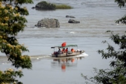 FILE - A Chinese boat with a team of geologists surveys the Mekong River, at the border between Laos and Thailand, April 23, 2017.