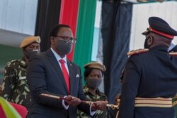 FILE - President Lazarus Chakwera receives a sword of office as commander-in-chief of the Malawi Armed Forces during his inauguration at the Kamuzu Baracks, the Malawi Defense Force Headquarters, in Lilongwe, July 6, 2020.