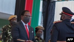 Le président élu du Malawi, Lazarus Chakwera, reçoit une épée d'office en tant que commandant en chef des forces armées du Malawi lors de son inauguration au Kamuzu Baracks, au siège des forces de défense du Malawi, à Lilongwe, le 6 juillet 2020.