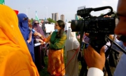 FILE - Wajiha Khanian, a journalist from TV channel Dawn News, interviews a protester in Islamabad, Pakistan, Sept. 11, 2020. Social media attacks against Pakistan's female journalists have been vile, with some threatening rape or death.