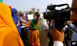 FILE - Wajiha Khanian, a journalist from TV channel Dawn News, interviews a protester in Islamabad, Pakistan, Sept. 11, 2020. Social media attacks against Pakistan's female journalists have been vile, with some threatening rape or death.