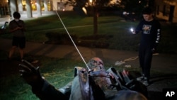 People film the only statue of a Confederate general, Albert Pike, in the nation's capital after it was toppled by protesters and set on fire in Washington early Saturday, June 20, 2020.