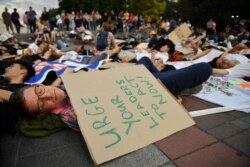 A climate change activist lies on the ground as youths stage a "drop dead" flash mob protest against climate change consequences at Lumpini Park in Bangkok, Thailand, Nov. 29, 2019.