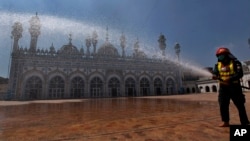 A rescue worker sprays disinfectant in the courtyard of a mosque in an effort to contain the outbreak of the coronavirus ahead of the Muslim fasting month of Ramadan, in Rawalpindi, Pakistan. April 21, 2020.