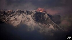 FILE - In this Oct. 27, 2011 file photo, the last light of the day sets on Mount Everest as it rises behind Mount Nuptse as seen from Tengboche, in the Himalaya's Khumbu region, Nepal.