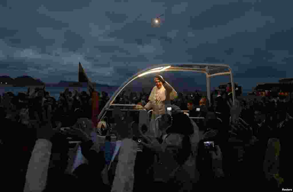 Pope Francis greets Catholic pilgrims during his arrival at Copacabana beach in Rio de Janeiro, July 25, 2013. Pope Francis is on the fourth day of his week-long visit for World Youth Day. REUTERS/Pilar Olivares (BRAZIL - Tags: RELIGION) - RTX11Z5E