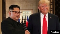 Pemimpin Korea Utara Kim Jong Un berjabat tangan dengan Presiden AS Donald Trump dalam pertemuan di Singapura, 12 Juni 2018 lalu. 