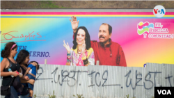  Dos mujeres pasan frente a un cartel con la imagen del presidente Daniel Ortega y su esposa, Rosario Murillo, en Managua.