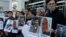 FILE - Pro-democracy activists hold pictures of Chinese activist Wu Gan (2nd-R) and other activists outside the Chinese central government's liaison office in Hong Kong, Dec. 27, 2017. 