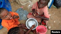 Internally displaced Somali children eat breakfast at Sayyidka camp in the Howlwadag district, south of Somalia's capital Mogadishu, May 3, 2013. 