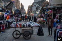 A man waits for costumers at his stand at a local market in the northern Syrian city of Qamishli, which is controlled by the U.S.-backed, Kurdish-led Syrian Democratic Forces, Jan. 28, 2025.