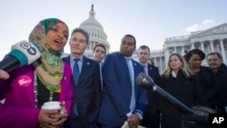 FILE - Rep. Ilhan Omar, D-Minn., left, Rep. Mike Levin, D-Calif., Rep. Christopher Pappas, D-N.H., Rep. Joe Neguse, D-Colo., and other freshmen member of the House of Representatives speak on Capitol Hill.