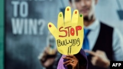 ILUSTRASI - Seorang aktivis mengikuti acara memperingati Hari Perempuan Sedunia di Banda Aceh, Aceh, 8 Maret 2019. Seorang pengunjuk rasa membawa spanduk bertuliskan "Stop Bullying". (Foto: AFP/Chaideer Mahyuddin)