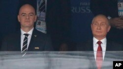 FIFA President Gianni Infantino, left, and Russian President Vladimir Putin stand for the anthems before the match between Russia and Saudi Arabia, which opens the 2018 World Cup at the Luzhniki stadium in Moscow, June 14, 2018. Russia has opened the event with two victories.