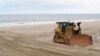 Una topadora en la playa Mantoloking, Nueva Jersey, lleva a cabo la reposición de arena en una área azotada por la supertormenta Sandy en 2012.