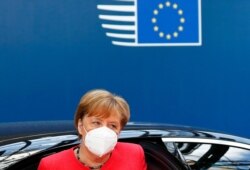FILE - German Chancellor Angela Merkel wears a protective face mask as she arrives for the continuation of an EU summit meeting in Brussels, Belgium, July 20, 2020.