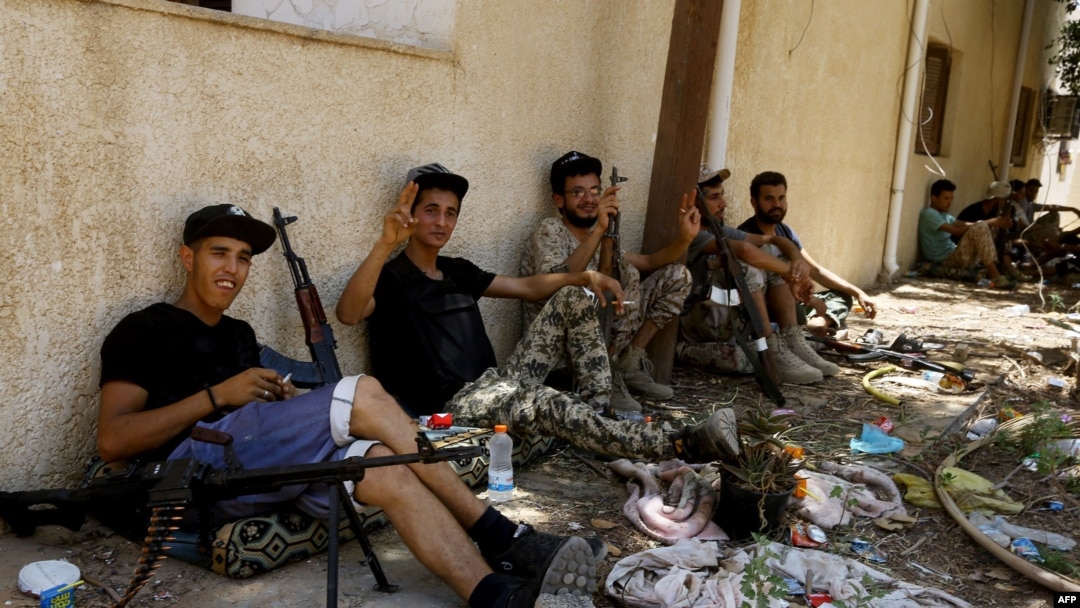 Fighters loyal to the internationally-recognized Libyan Government of National Accord (GNA) take a rest near their weapons in the al-Sawani area during clashes with forces loyal to Libya strongman Khalifa Haftar, June 19, 2019.