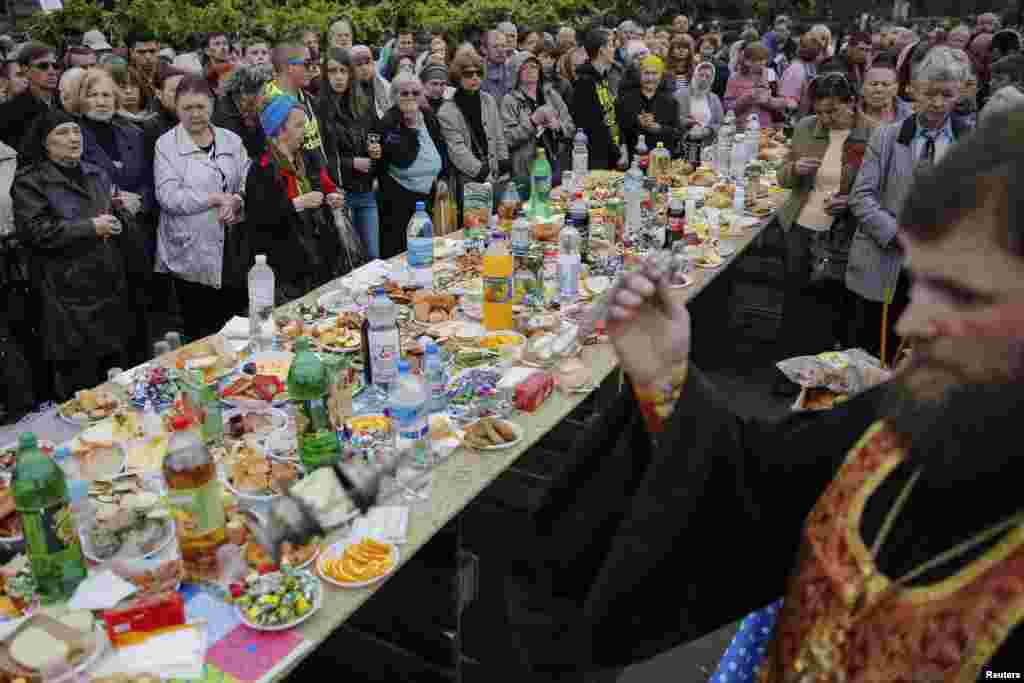 Masyarakat lokal berkumpul untuk sebuah upacara Orthodox untuk menghormati kematian para pendukung pro-Rusia yang tewas baru-baru ini di kota pelabuhan Laut Hitam, Odessa, Ukraina (10/5). (Reuters/Yevgeny Volokin)