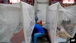 A relative visits a patient receiving treatment for dengue at University School Hospital in Tegucigalpa, Honduras, Aug. 20, 2019.