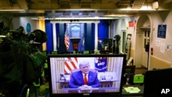 An image on a monitor shows U.S. President Donald Trump speaking during in a video posted on the White House Twitter feed, in the empty Brady Briefing Room of the White House in Washington, Jan. 13, 2021.