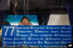 A child looks out from a public bus window in Bangkok, Thailand, Nov. 4, 2020.