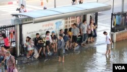 Para warga Bangkok yang mengungsi di bandara Don Muang sedang menunggu bis yang akan mengangkut mereka ke tempat lain yang lebih tinggi (25/10).