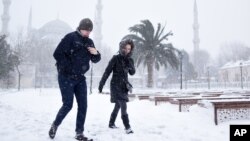 People walk in the snow, in the historic Sultanahmet district in Istanbul, Jan. 7, 2017. Heavy snow clogged roads, shipping traffic in Bosphorus and forced hundreds of flight cancellations in the Turkish metropolis. 