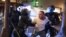  Les policiers de Portland retiennent un homme qui était visé par des tirs de balles le 29 août 2020 à Portland, Oregon. (Photo: Nathan HOWARD / GETTY via AFP)