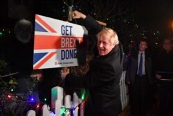 FILE - Britain's Prime Minister and Conservative party leader Boris Johnson poses with a sledgehammer, after hammering a "Get Brexit Done" sign into the yard of a supporter, in South Benfleet, Britain, Dec. 11, 2019.