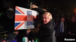 FILE - Britain's Prime Minister and Conservative party leader Boris Johnson poses with a sledgehammer, after hammering a "Get Brexit Done" sign into the yard of a supporter, in South Benfleet, Britain, Dec. 11, 2019.